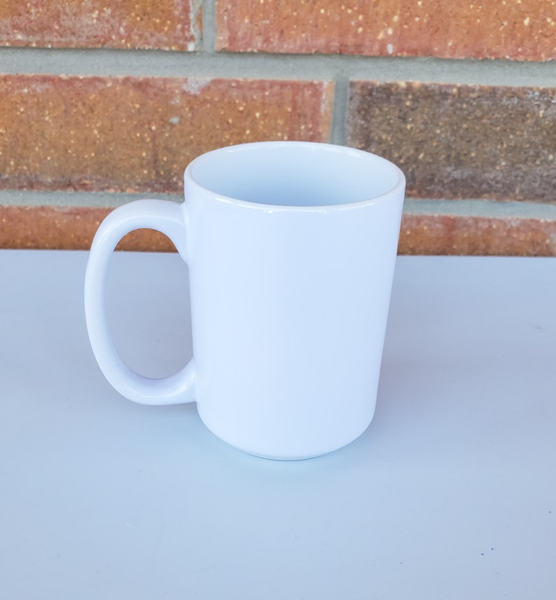 May include: A white ceramic mug with a large handle. The mug is blank and ready to be customized.