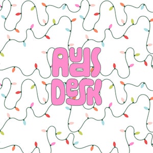May include: A pink graphic with the text "A Day At The Desk" on a white background with a pattern of green string lights with colorful bulbs.