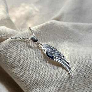 K&ouml;nnte beinhalten: Eine wei&szlig;e Keramik-Tasse mit schwarzem Henkel und dem Text "But First, Coffee" in schwarzer, handschriftlicher Schrift. Die Tasse steht auf einer wei&szlig;en Oberfl&auml;che.