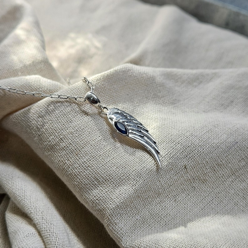 K&ouml;nnte beinhalten: Eine wei&szlig;e Keramik-Tasse mit schwarzem Henkel und dem Text "But First, Coffee" in schwarzer, handschriftlicher Schrift. Die Tasse steht auf einer wei&szlig;en Oberfl&auml;che.