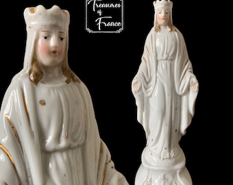 Puede incluir: Estatua de porcelana blanca de una mujer con corona y túnica, con detalles dorados. La figura tiene una expresión serena y las manos extendidas. La imagen incluye el texto "Treasures of France".