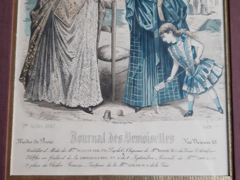 Puede incluir: Una ilustraci&oacute;n vintage de la revista Journal des Demoiselles, fechada el 15 de julio de 1887. La imagen representa a tres mujeres vestidas con ropa de moda, dos mujeres de pie y una ni&ntilde;a jugando con un palo en el suelo. Las mujeres llevan vestidos largos con detalles intrincados, y la ni&ntilde;a lleva un vestido a rayas con un cuello con volantes.