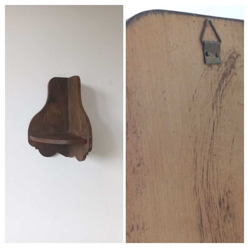 K&ouml;nnte beinhalten: Ein Eckregal aus Holz mit einem dekorativen, geschnitzten Rand. Das Regal ist braun und hat ein schlichtes Design. Es ist an einer wei&szlig;en Wand montiert.