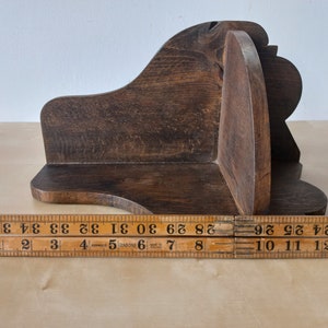 K&ouml;nnte beinhalten: Ein dunkelbraunes Eckregal aus Holz mit einem geschwungenen Design. Das Regal ist etwa 25 cm breit.