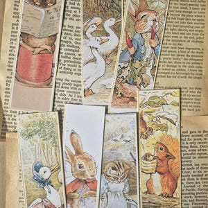 Puede incluir: Una colección de siete marcapáginas rectangulares de papel con ilustraciones de animales de estilo vintage, que incluyen un ratón leyendo, patos, un conejo con una zanahoria, un pato con capota, un conejo con capa roja, un gatito y una ardilla.