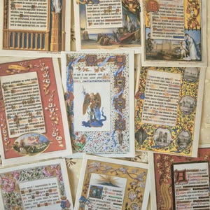 Op de afbeelding: Een verzameling rechthoekige kaarten met gedrukte reproducties van verluchte manuscripten. Elke kaart toont ingewikkelde randen, versierde bloemmotieven, religieuze illustraties en dichte zwarte tekst in Franse en Latijnse schriften.