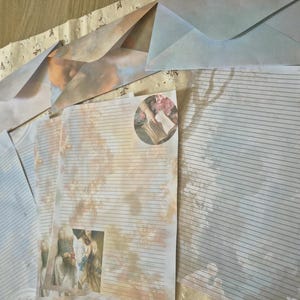 Puede incluir: Un conjunto de papelería con hojas rayadas y sobres a juego. El papel muestra imágenes suaves y tenues de nubes, árboles y figuras clásicas en tonos naranja cálido y azul frío, con detalles artísticos circulares y rectangulares.