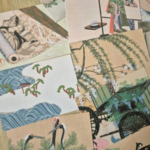 K&ouml;nnte beinhalten: Eine Sammlung rechteckiger Postkarten mit verschiedenen traditionellen japanischen Kunstdrucken, darunter Darstellungen von Kranichen, Weidenb&auml;umen, verzierten Kutschen, Figuren in historischer Kleidung sowie Landschaftsszenen mit flie&szlig;endem Wasser und Kiefern.