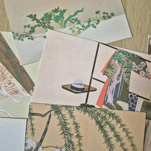 K&ouml;nnte beinhalten: Eine Sammlung rechteckiger Papierkarten mit verschiedenen Illustrationen, darunter gr&uuml;ne Blattpflanzen, ein kleiner Tisch mit einer Schale, ein gemustertes Kleidungsst&uuml;ck und lange, herabh&auml;ngende Weidenzweige mit wei&szlig;en Bl&uuml;ten auf beigem Grund.