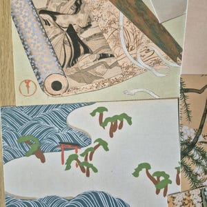 K&ouml;nnte beinhalten: Eine Sammlung rechteckiger Papierdrucke mit traditioneller japanischer Kunst. Ein Druck zeigt eine Figur mit langem schwarzem Haar in einer rollenartigen Komposition, w&auml;hrend ein anderer eine Landschaft mit stilisierten blauen Wellen, gr&uuml;nen B&auml;umen und einem roten Torii-Tor darstellt.