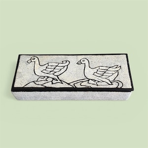 May include: Rectangular box with a mosaic-style top featuring two stylized white ducks with black outlines. The box has a black border and a textured, crackled surface, set against a light green background.