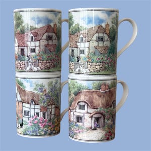 May include: Four ceramic mugs arranged in a two-by-two grid, each featuring a detailed illustration of a cottage with a thatched roof, stone walls, and a garden filled with colorful flowers. Each mug has a white handle and a cylindrical shape.