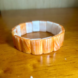 Thick cut, orange spiny oyster shell bracelet. Comfy elastic, wide fit.