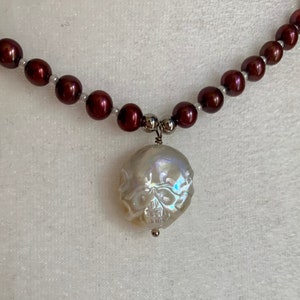 Dainty, pearl choker necklace with skull carved pearl pendant.