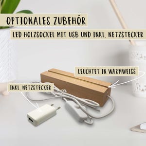 Könnte beinhalten: Rechteckiger LED-Holzsockel mit warmweißem Licht, USB und Netzteil. Der Sockel ist für ein dekoratives Objekt konzipiert. Das Bild zeigt auch das Netzteil und ein weißes Kabel.