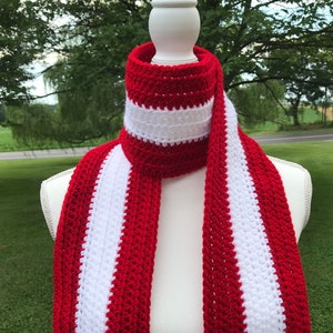 Red and white striped crocheted scarf draped around the neck of a mannequin.  Stripes run lengthwise on the scarf.  There are two red stripes on the outside lengths of the scarf, and the center stripe is white.