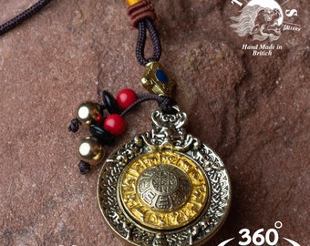 Puede incluir: Un collar con un colgante redondo de oro y plata con un diseño adornado que presenta una tortuga. El colgante está en un cordón marrón con cuentas rojas y negras. El collar está etiquetado como "TIMES GALLERY" y "Hand Made in Brittich".