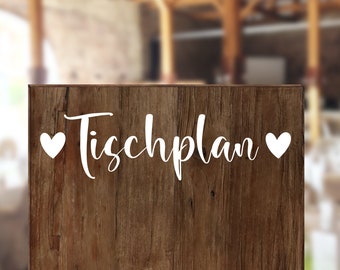 May include: A wooden sign with the text "Tischplan" in white lettering, surrounded by two white hearts.