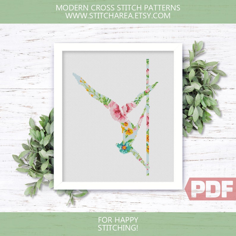 Puede incluir: Un patr&oacute;n de punto de cruz con una persona haciendo telas a&eacute;reas, con un dise&ntilde;o floral en tonos de rosa, azul, amarillo y verde. El patr&oacute;n est&aacute; en un marco blanco con el texto "MODERN CROSS STITCH PATTERNS WWW.STITCHAREA.ETSY.COM" en la parte superior y "FOR HAPPY STITCHING!" en la parte inferior. La imagen tambi&eacute;n incluye la palabra "PDF" en un cuadro rojo.