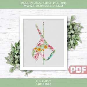 Puede incluir: Un patr&oacute;n de punto de cruz con un dise&ntilde;o floral de una persona haciendo pole dance. El patr&oacute;n est&aacute; en un marco blanco y tiene una etiqueta PDF en la esquina inferior derecha. El texto "FOR HAPPY STITCHING!" est&aacute; debajo del marco.