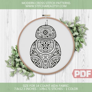 May include: A black and white cross-stitch pattern of a droid, displayed in a wooden embroidery hoop. The droid design features floral and geometric patterns. The text "MODERN CROSS STITCH PATTERNS" and "WWW.STITCHAREA.ETSY.COM" are visible. The pattern size is 7.8x12.3 inches.