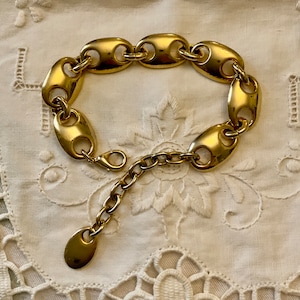 Peut inclure: Un bracelet doré avec un design de chaîne à maillons. Le bracelet est doté d'un fermoir à ressort.