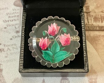 May include: A vintage pink and green flower brooch in a clear glass dome setting. The brooch is in a black velvet box.