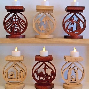 May include: Six wooden candle holders with a Christmas theme. Each holder features a different scene from the Nativity story, including the three wise men, the shepherds, and the manger. The holders are made of natural wood and have a rustic look.