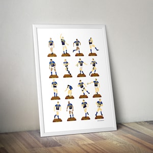 Puede incluir: Una impresión enmarcada en blanco con 20 ilustraciones de dibujos animados de jugadores de rugby con uniformes azules y dorados. Los jugadores están representados en varias poses, sosteniendo una pelota de rugby o en posición de carrera. La impresión está sobre un fondo blanco y tiene un borde dorado.