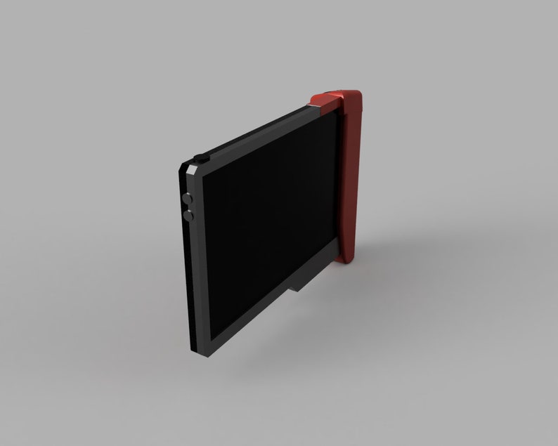 Op de afbeelding: Een zwart handheld-apparaat met een rode zijpaneel en een zwart scherm. Het apparaat heeft twee kleine zwarte knoppen aan de zijkant.