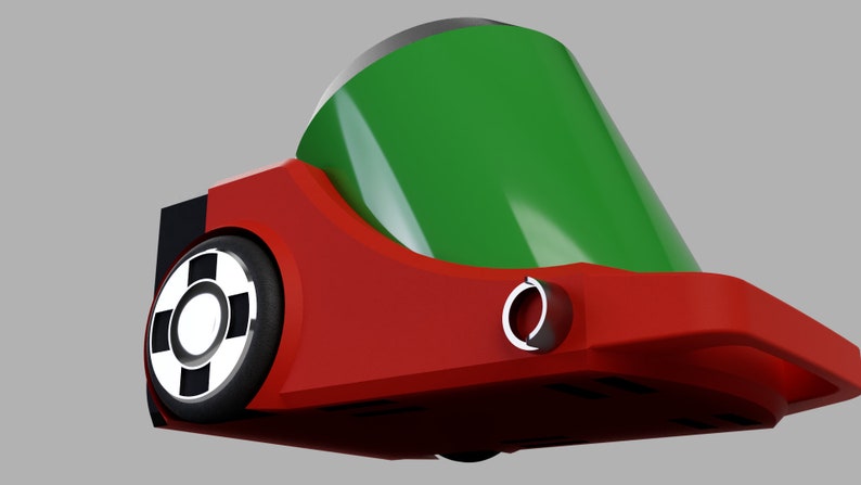 Puede incluir: Un coche de juguete rojo y verde con una rueda negra y un c&iacute;rculo blanco en el centro. El coche tiene un techo verde y un cuerpo rojo.