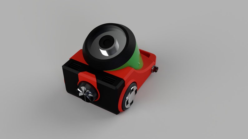 Puede incluir: Un robot de juguete rojo y negro con una parte superior verde y plateada. El robot tiene una rueda grande en la parte superior y una rueda m&aacute;s peque&ntilde;a en el lateral.