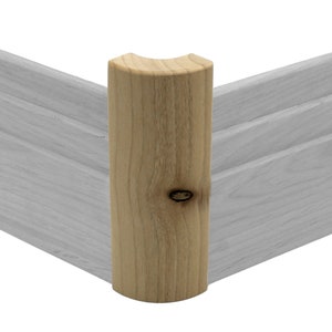 May include: A wooden corner trim piece with a rounded edge. The trim is made of natural wood with a knot and is a light brown color.