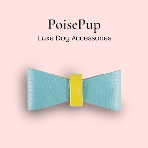 May include: A light blue leather bow tie with a yellow center.  PoisePup Luxe Dog Accessories.