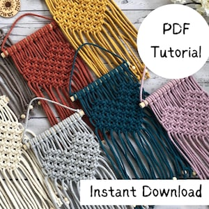 Peut inclure: Cinq tentures murales en macramé de couleurs différentes avec des chevilles en bois. Les couleurs sont beige, orange, jaune, sarcelle et rose. Le texte "Tutoriel PDF" et "Téléchargement instantané" est visible sur l'image.