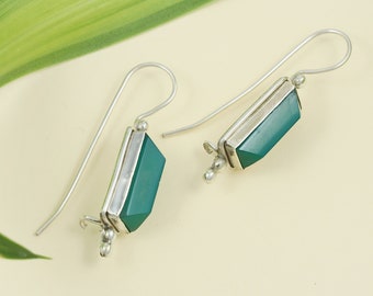 May include: A pair of silver dangle earrings with green gemstone rectangular drops.