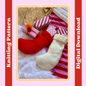 May include: Two knitted Christmas stockings, one red and one white, are displayed on a white fluffy surface. The stockings are surrounded by wrapped gifts with red and white stripes, pink and yellow wrapping paper, and a checkered pattern.