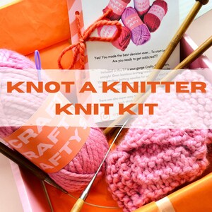 May include: A pink knitting kit containing two balls of yarn, two knitting needles, and a partially knitted pink scarf. The kit is labelled "Knot a Knitter Knit Kit" and "Crafty Aftly".