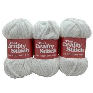 May include: Three white balls of yarn labeled "That Crafty Stitch The Squishy One"