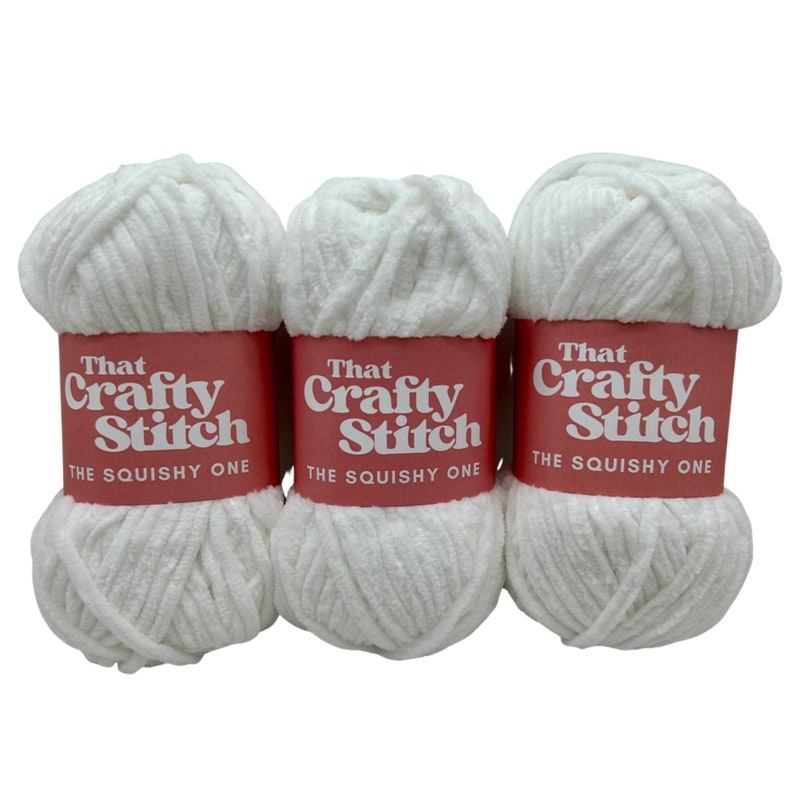 May include: Three white balls of yarn labeled "That Crafty Stitch The Squishy One"