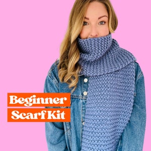 May include: A beginner scarf kit with a blue knitted scarf. The scarf is being worn by a person with long blonde hair. The text "Beginner Scarf Kit" is in orange letters on a white background.