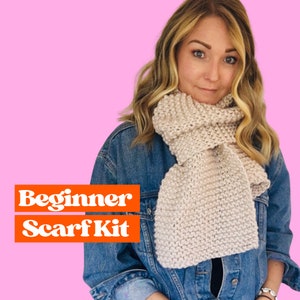 May include: A woman wearing a denim jacket and a light beige knitted scarf. The text "Beginner Scarf Kit" is displayed in orange letters on a white background.
