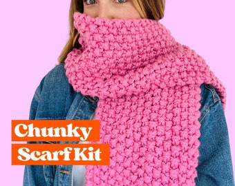 May include: A pink chunky knit scarf kit. The scarf is made with a thick yarn and has a simple stitch pattern. The kit includes the yarn and instructions.