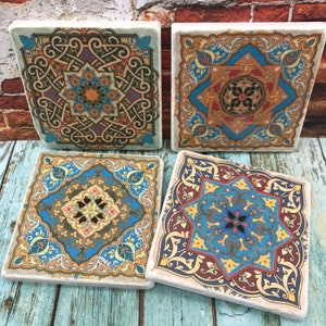 May include: Set of four square ceramic coasters featuring intricate geometric patterns in shades of blue, red, yellow, and green. The coasters have a traditional Moroccan design.