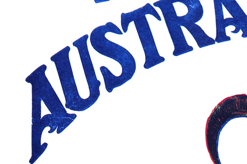 K&ouml;nnte beinhalten: Nahaufnahme des Wortes "AUSTRALIA", das in dunkelblauer Tinte auf wei&szlig;em Hintergrund gedruckt ist.