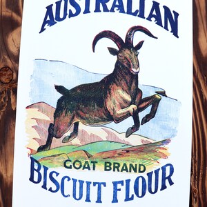 K&ouml;nnte beinhalten: Vintage-Illustration eines springenden Ziegenbocks vor einer Bergkette. Der Text lautet "Finest Australian Goat Brand Biscuit Flour 50 lbs Gross Weight When Packed".