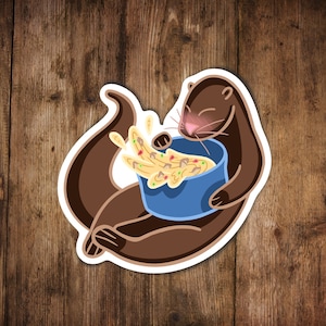 Puede incluir: Una nutria de dibujos animados marrón sosteniendo un tazón azul lleno de comida amarilla, naranja y verde. La comida se derrama del tazón.