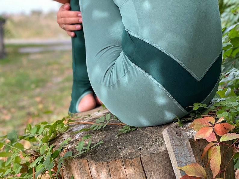 May include: A pair of teal green leggings with a dark green chevron design on the back.
