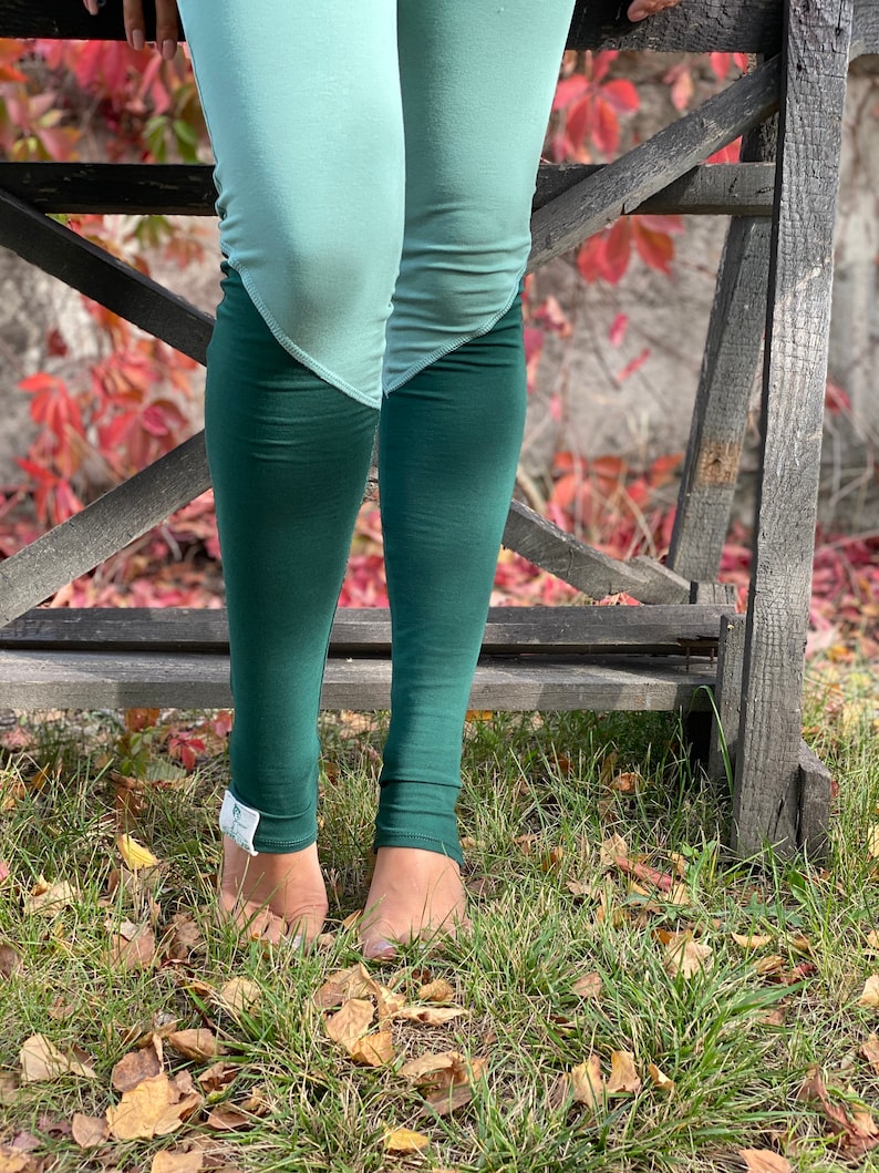 May include: A pair of green and light blue leggings with a color block design. The leggings are made of a soft, stretchy fabric and are perfect for yoga, running, or everyday wear.
