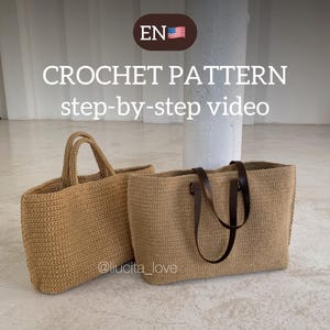 Puede incluir: Dos bolsas de mano de crochet, una con asas de cuero marrón, sobre un suelo de baldosas de color gris claro. El texto "CROCHET PATTERN step-by-step video" está por encima de las bolsas. El texto "EN" y una pequeña bandera estadounidense están en un círculo por encima del texto.